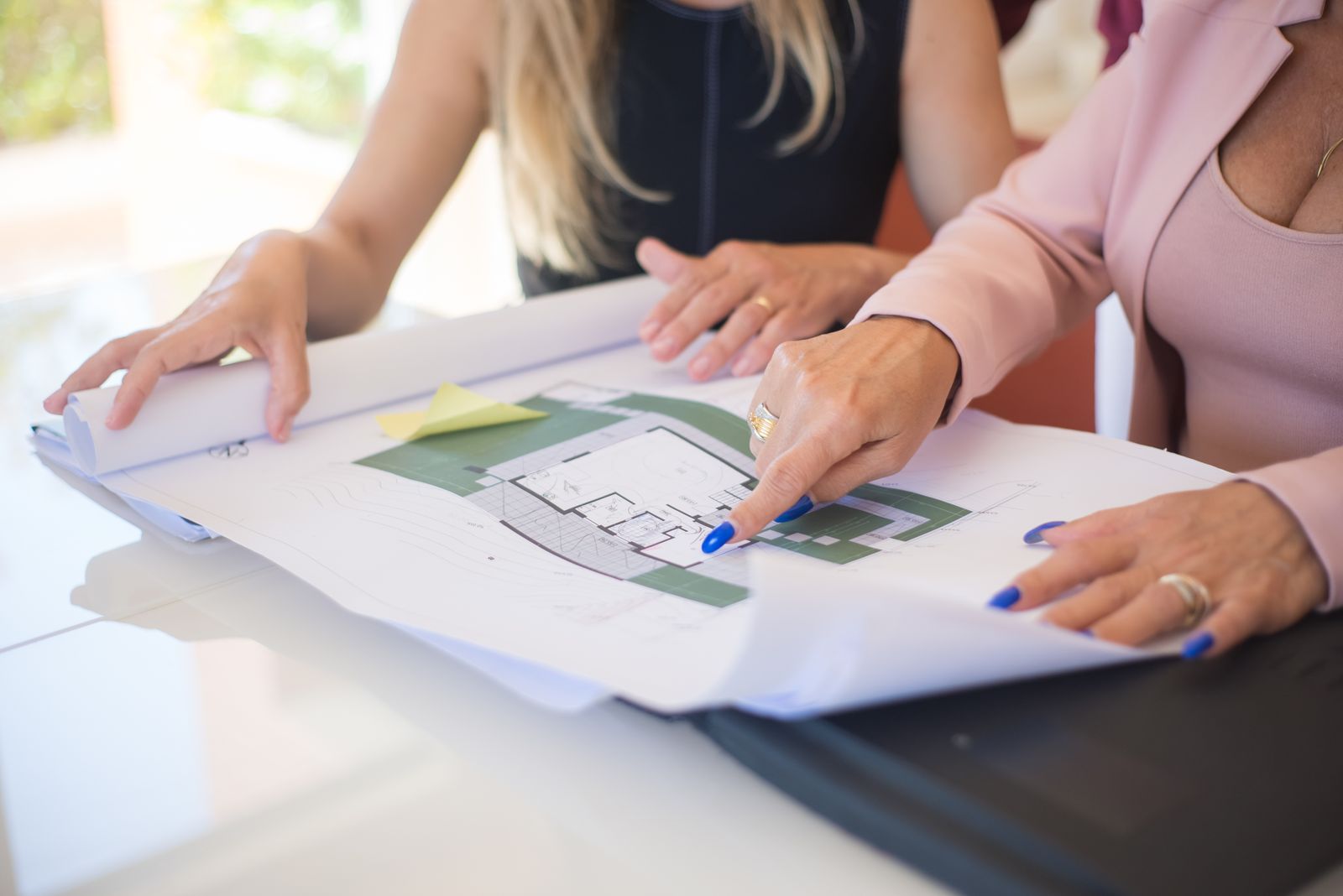Estimator and facility manager reviewing roof drawings